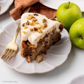 Slice of apple cake on a white fluted plate.
