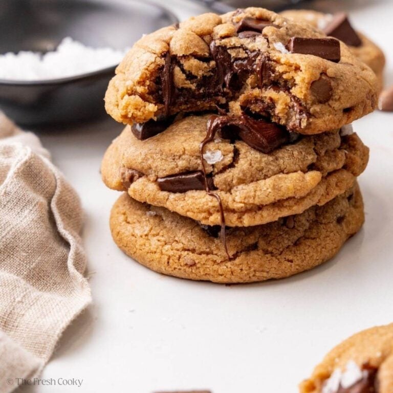 Brown butter chocolate chip cookies stacked with one bitten into.