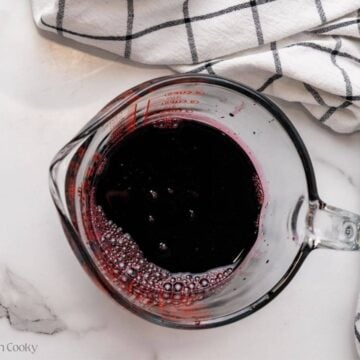 Strained syrup into a glass measuring cup.