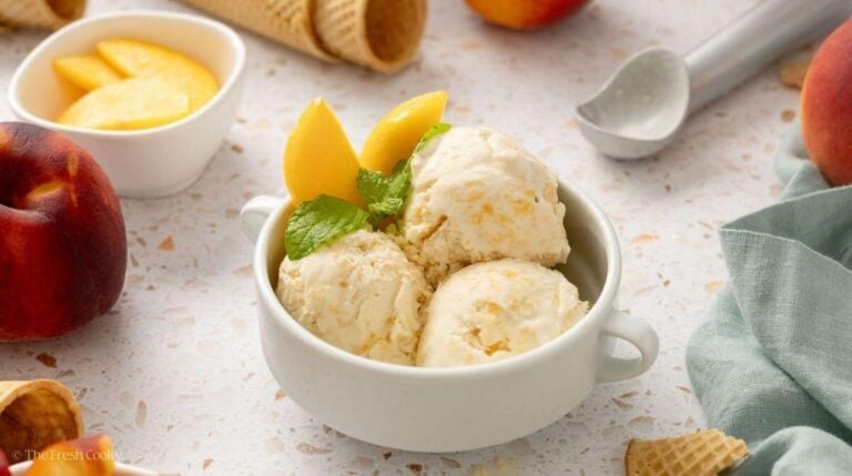 Three scoops of fresh peach ice cream in a bowl.