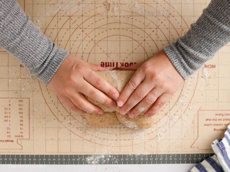 Hands holding the dough after rolling it up and shaping it.