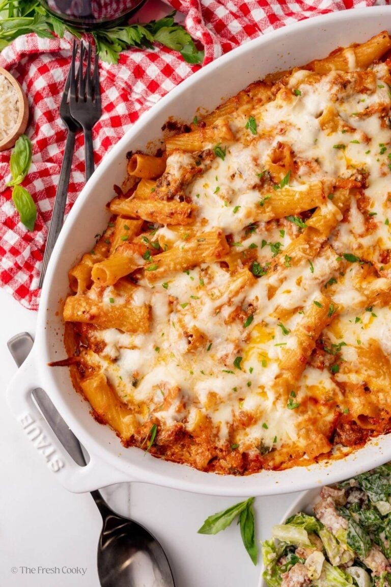 Overhead shot of baked rigatoni in an oval white baking dish.
