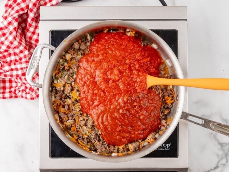 Canned tomatoes added to the meat sauce mixture.