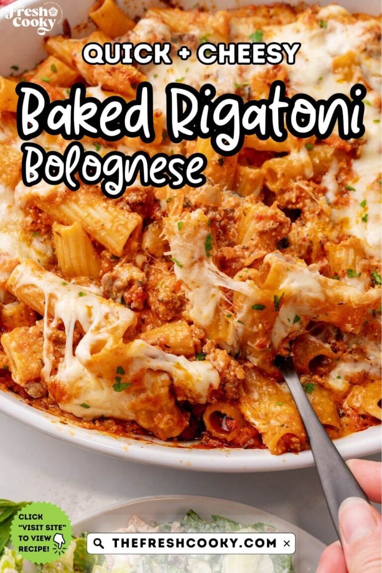 Pan of meaty, cheesy baked rigatoni with a spoon, for pinning.