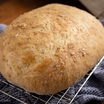 Italian bread loaf on a wire rack to cool.