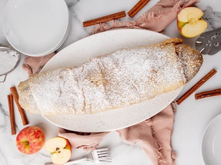 Overhead shot of a full German apple strudel on a serving plate.