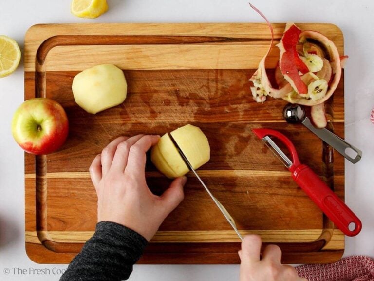 Thinly slicing the apples without going all the way through on a wooden board.