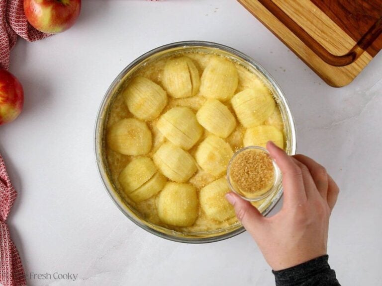 Spreading coarse sugar on top of the apfelkuchen.