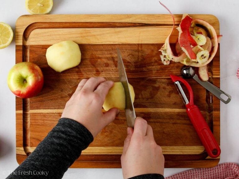 Using a sharp knife to thinly slice the apples.