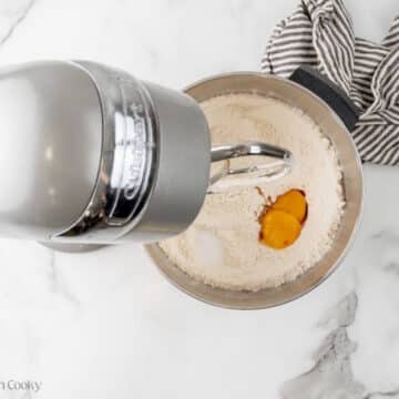 Adding egg yolks to flour mixture.