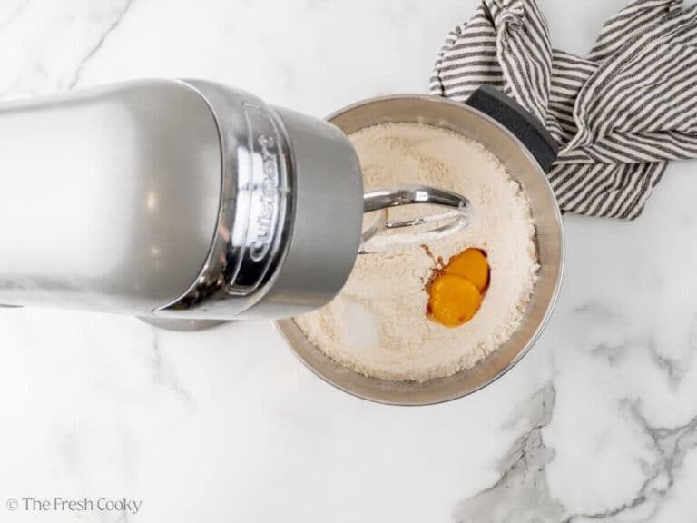 Adding egg yolks to flour mixture.