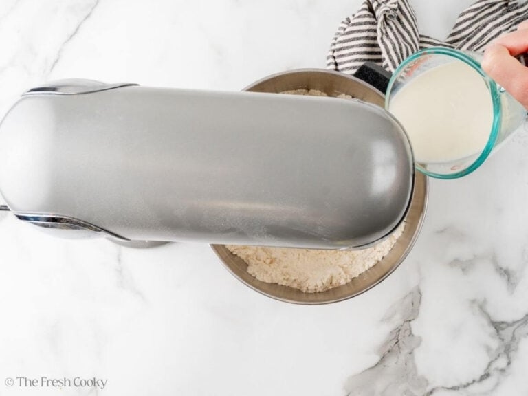 Pouring milk into flour and yeast mixture.