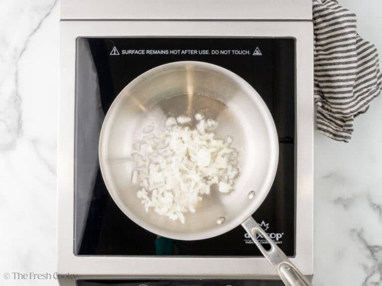 Onions cooking in oil in a pan.