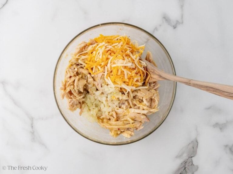 Shredded cheese and sauteed onions added to the shredded chicken mixture.