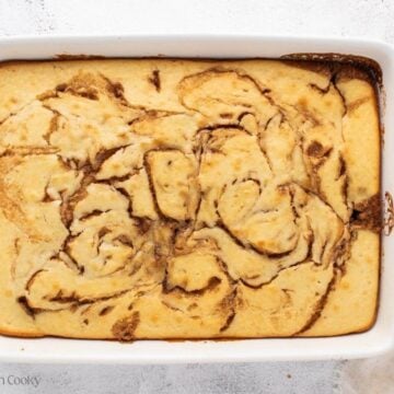 Baked cinnamon roll coffee cake in a white baking dish.