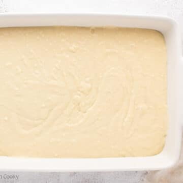 Cake batter added to a white baking dish.