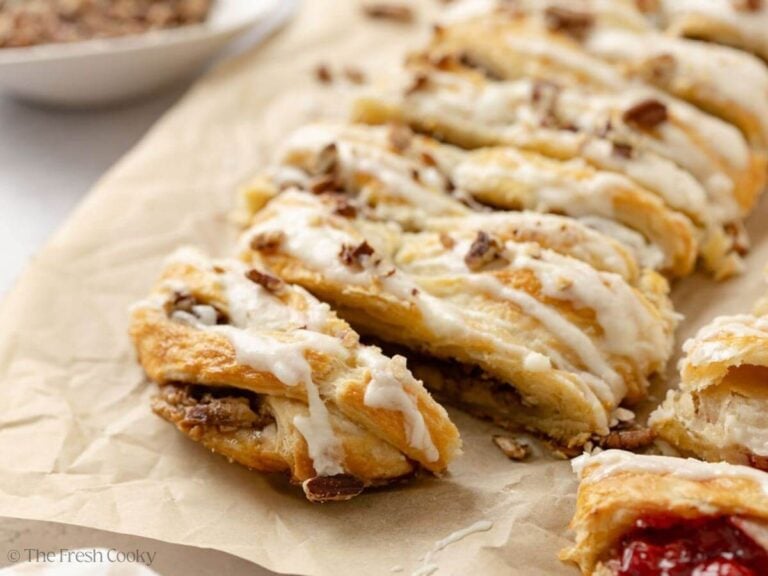 Close up of a pecan pie filled Danish kringle on a piece of parchment paper.