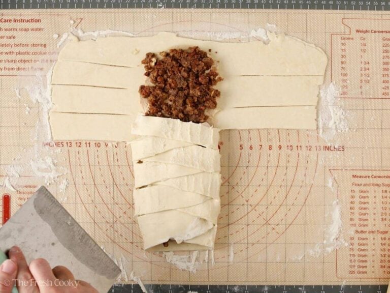 Dough strips being folded over the top of the filling.