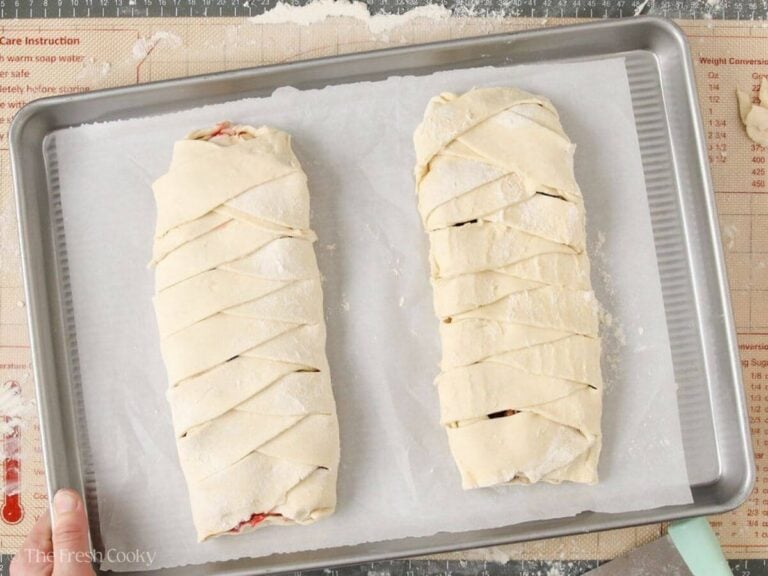 Two Danish kringles places on a sheet pan lined with parchment paper.