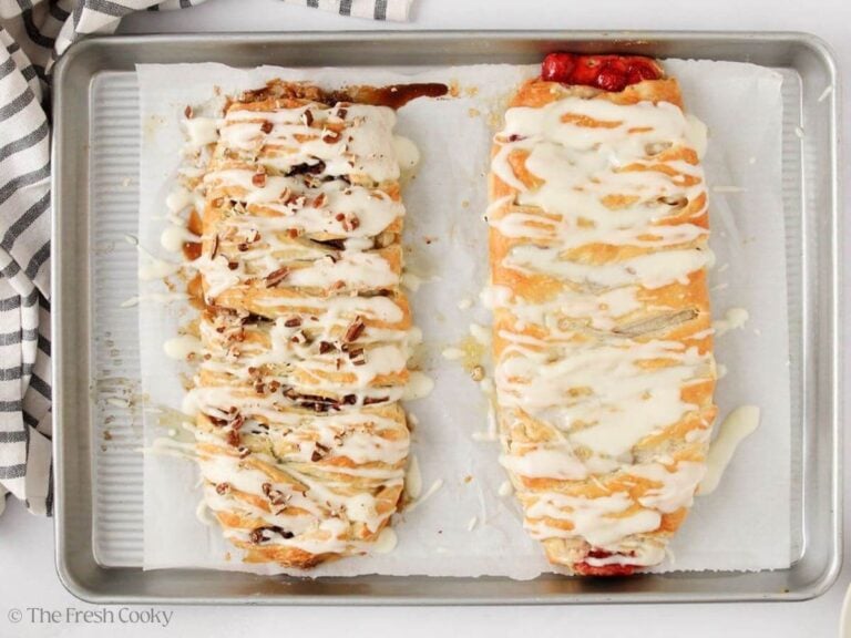 Overhead shot of two Danish kringles on a sheet pan with a glaze on top.