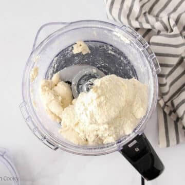 Butter and sour cream added to the flour in a food proccesor.