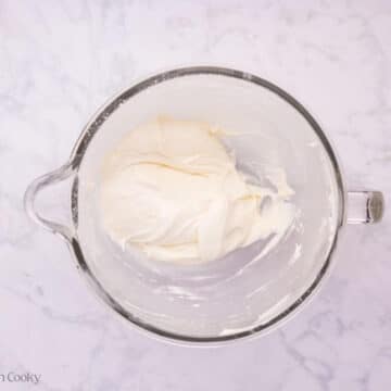 Cream cheese frosting in the bowl of a stand mixer.