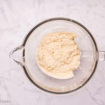 Cinnamon roll dough in a stand mixer bowl before kneading.