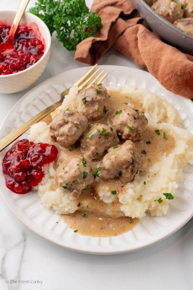Swedish meatballs on a plate with mashed potatoes and ligonberry jam.