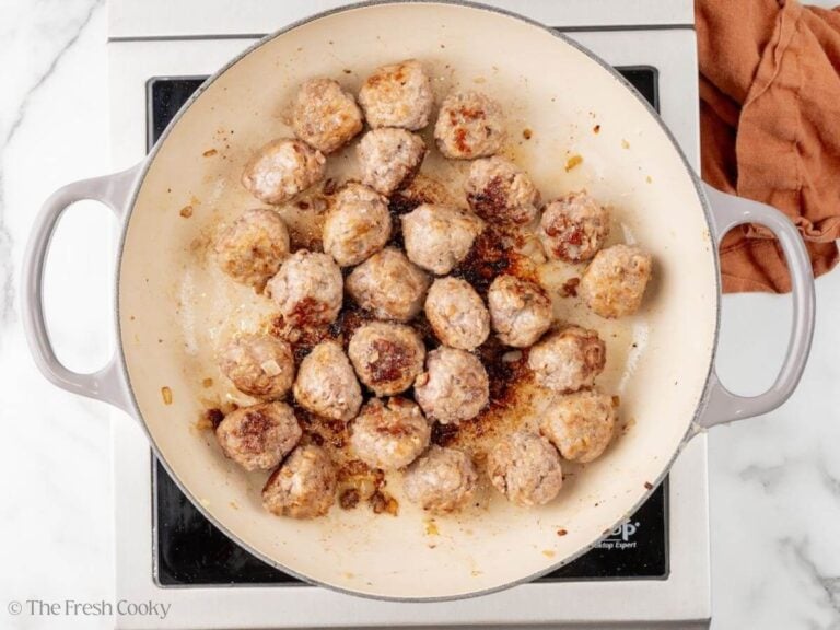 Seared and cooked meatballs in a skillet.