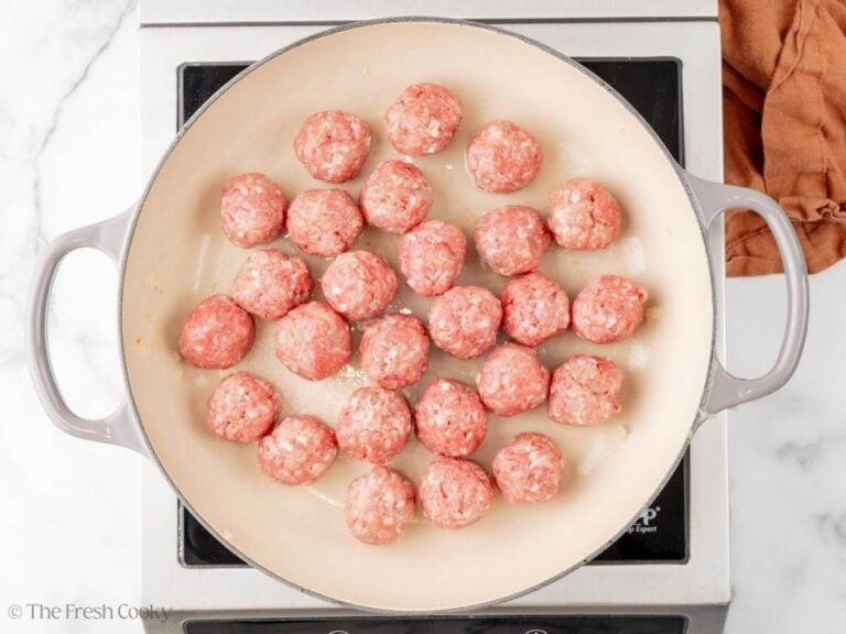 Meatballs in a skillet to cook.