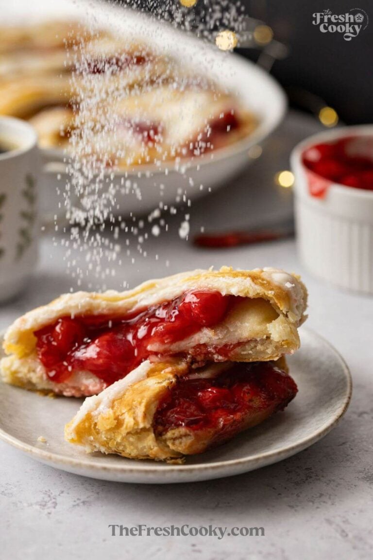 Sprinkling powdered sugar over a cherry Kringle, for pinning.