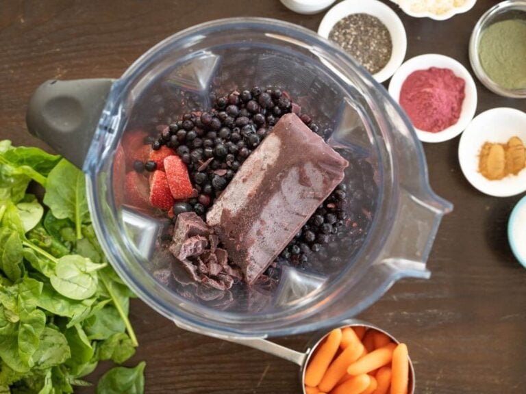 Overhead shot of fruits added to a blender.