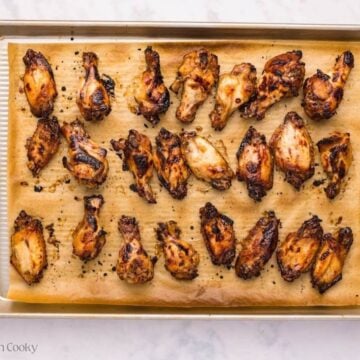Broiled sticky chicken wings on a sheet pan.