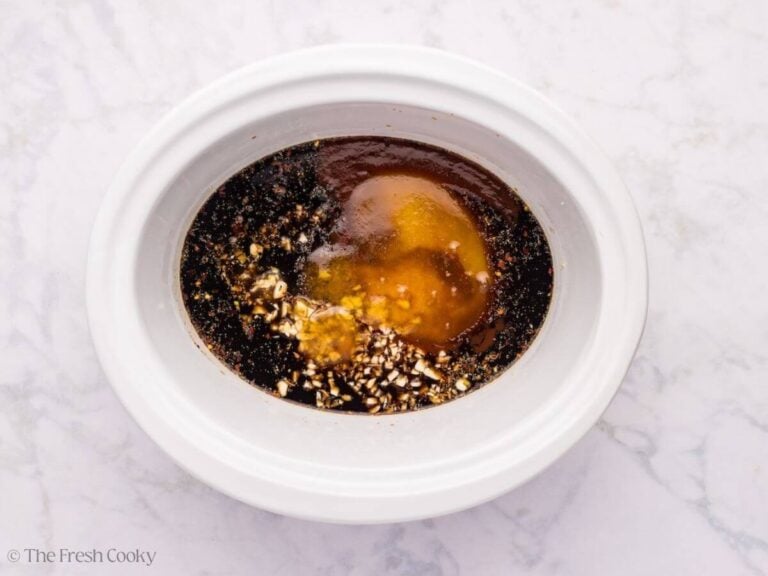 Sticky chicken wing sauce in the bottom of a crockpot.