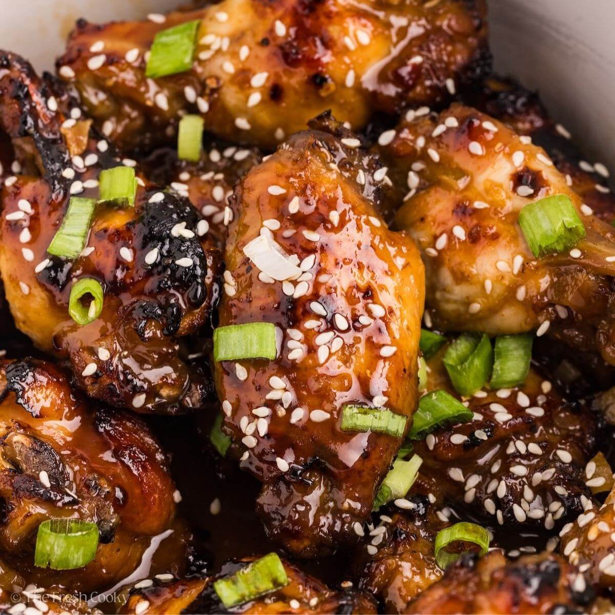 Close up of sticky chicken wings piled in the slow cooker.