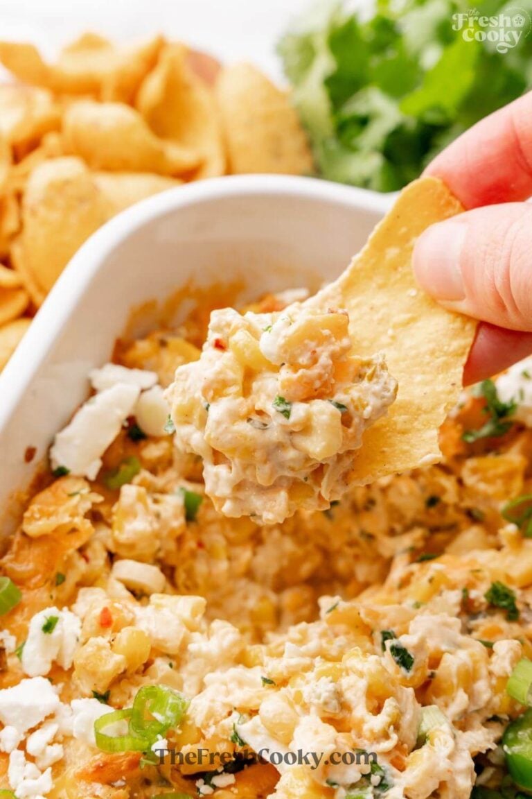 Easy corn dip in white baker, with hand scooping it up from corn chip, for Pinning.