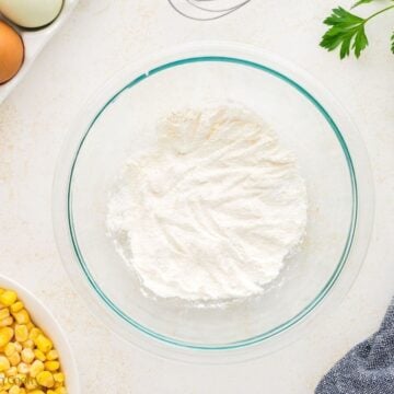Sugar, flour, baking powder and salt mixed together in a mixing bowl.
