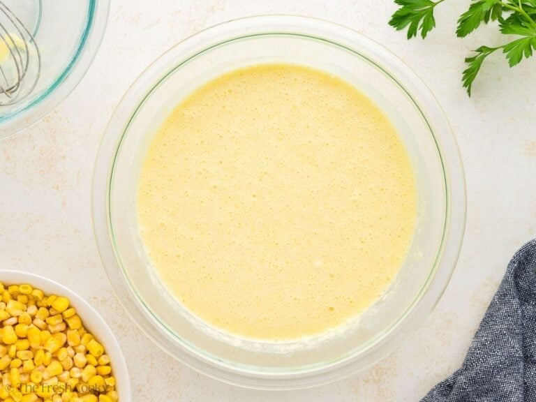 Wet and dry ingredients mixed together in a mixing bowl.