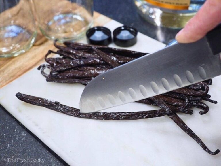 Slicing through the center of the vanilla bean with a knife.