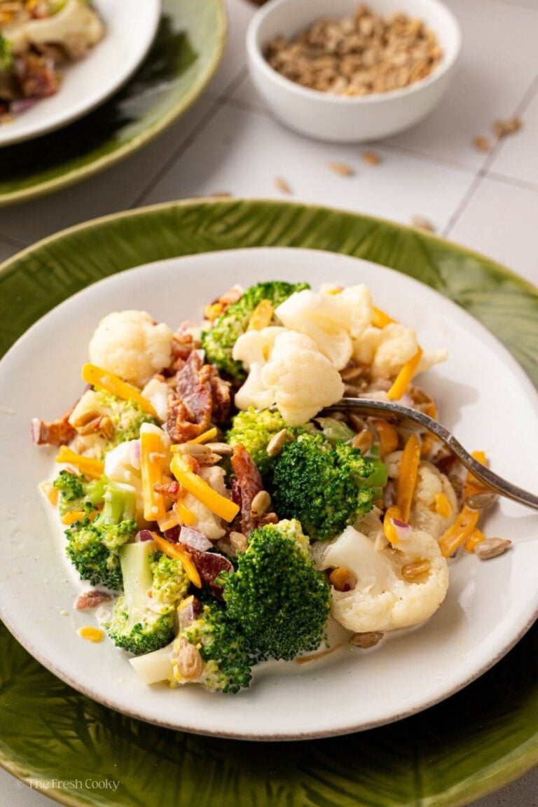 Broccoli cauliflower salad on a white plate with a fork.