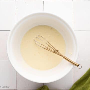 Whisking the salad dressing in a large bowl.