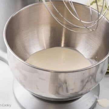 Heavy cream in the bowl of a stand mixer.