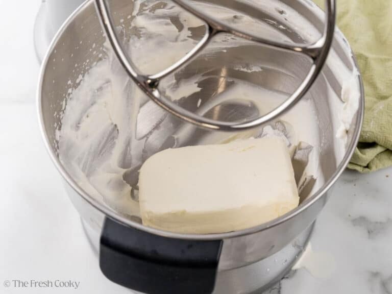 Cream cheese added to the bowl of a stand mixer.