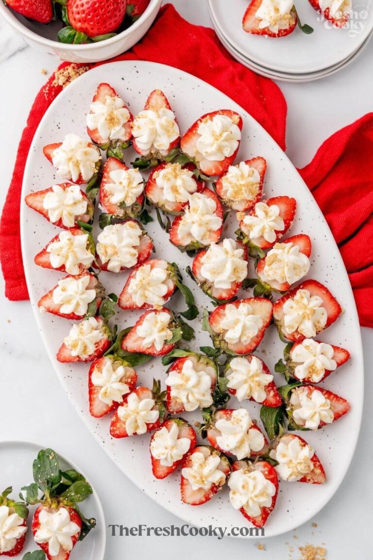 A platter of deviled strawberries, halves of strawberries topped with a star "kiss" of cheesecake filling. To pin.