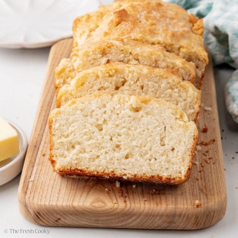 No yeast bread loaf on cutting board with slices.
