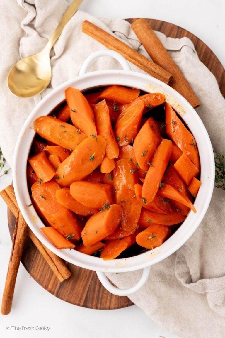 Overhead shot of slow cooker glazed carrots in a white serving dish.