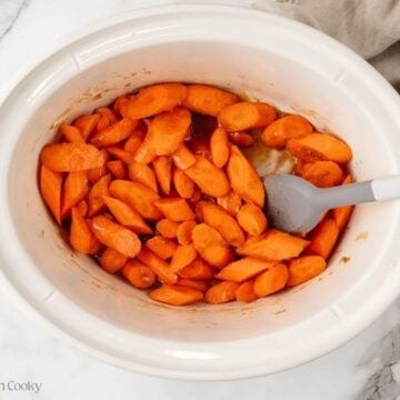Carrots and glaze mixed together in the crockpot before cooking.