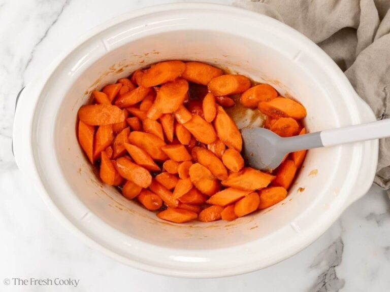 Carrots and glaze mixed together in the crockpot before cooking.