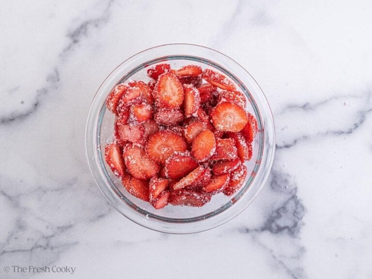 A glass bowl of sugar-coated strawberries.