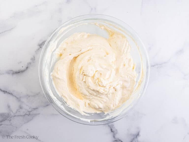 A glass bowl with whipped pudding mixture for strawberry banana pudding.